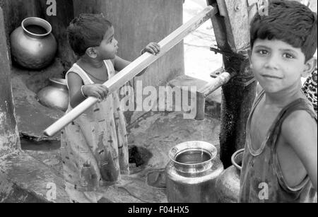 indian children getting water from well brian mcguire Stock Photo