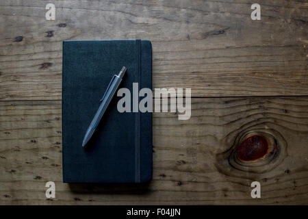 Leather Notebook with Silver Pen on a Wooden Table Stock Photo