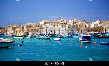 Colorful boats and moroccan style buildings in Marsaxlokk Fishing Village, Malta Stock Photo