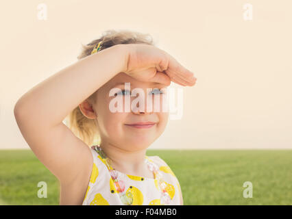 Little girl looking forward with the hand in forehead Stock Photo