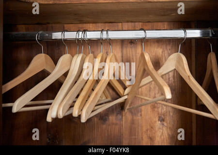 An open wardrobe rail with wooden coat hangers Stock Photo