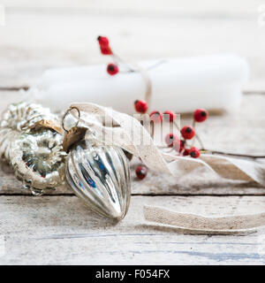 white candles tied with twine, red berries and silver baubles Stock Photo