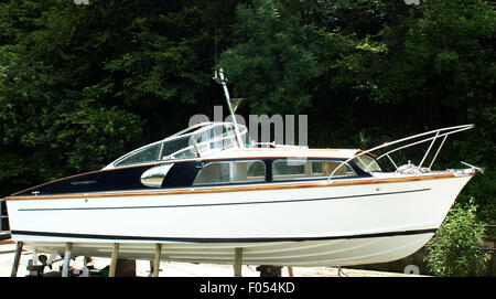 profile of Classic power boat, Fairey Huntsman, propped up on stilts after a repaint. Stock Photo