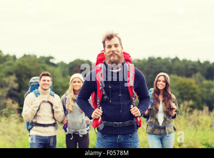 group of smiling friends with backpacks hiking Stock Photo