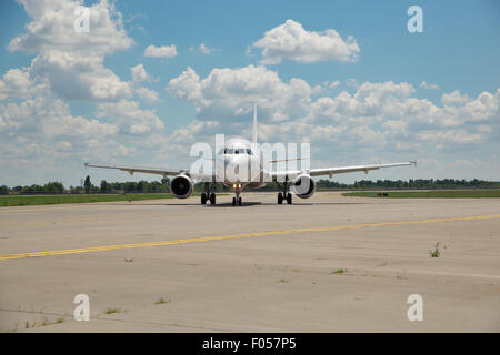 White passenger jet plane on runway in the airport on a sunny summer day Stock Photo