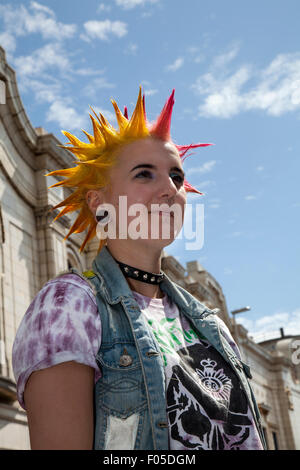 Punks with mohican dyed yellow & red hair, punk rockers Mohawk Liberty spikes mohican hairstyle at Blackpool, Lancashire, UK.Aug, 2015. Punk Rebellion festival at The Winter Gardens. A clash of cultures at the famous seaside town of Blackpool as punks attending the annual Rebellion festival at the Winter Gardens come shoulder to shoulder with traditional holidaymakers. Stock Photo