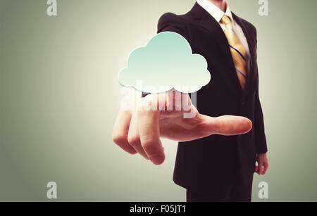 Businessman pushing a cloud icon over green vintage background Stock Photo