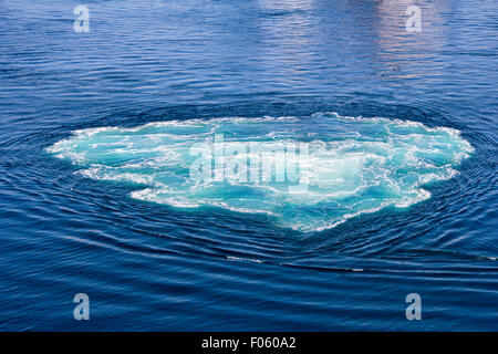 Turquoise green Swirl in seawater with sea foam as background Stock Photo