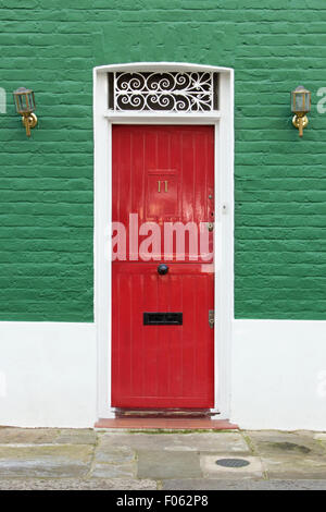 Red door in green and white wall Stock Photo