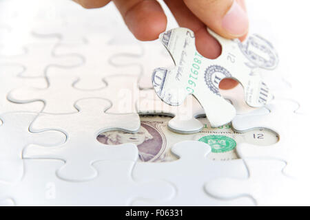 hand holding a puzzle piece, Finance concept Stock Photo