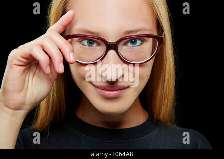 Smiling young blonde woman with her hand on her glasses Stock Photo