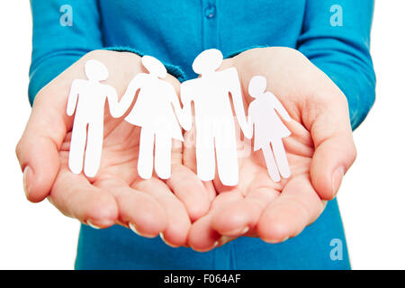 Paper family with parents and children laying in female hands Stock Photo