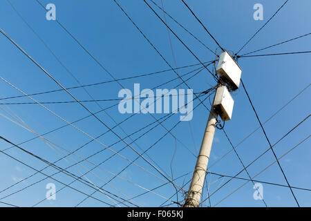 Power pole with white boxes with many electric cables in gypsy neighborhood in Sofia, Bulgaria. Stock Photo