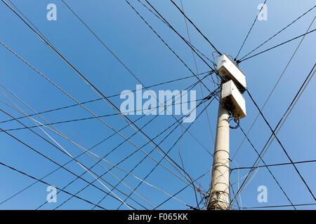 Power pole with white boxes with many electric cables in gypsy neighborhood in Sofia, Bulgaria. Stock Photo