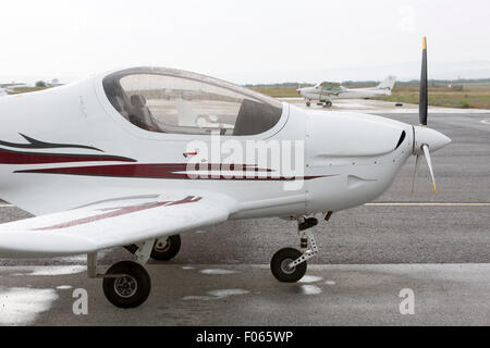 Small two-seated propeller airplane on the ground at the airport. Stock Photo