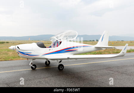 Small two-seated propeller airplane on the ground at the airport. Stock Photo