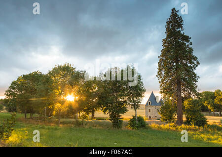 A small, hidden, pitoresk castle during a beautiful sunset on farmland. Stock Photo