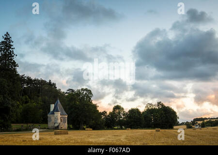A small, hidden, pitoresk castle during a beautiful sunset on farmland. Stock Photo