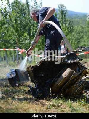 Ottersweier, Germany. 8th Aug, 2015. A fireman cleans the remains of the engine of the American fighter bomber 'Thunderbolt P-47' which got party recovered in Ottersweier, Germany, 8 August 2015. The plane crashed close to the town 14 February 1945, its 25 year old French pilot Antoine Allard died. Photo: PATRICK SEEGER/dpa/Alamy Live News Stock Photo