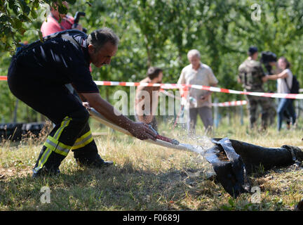 Ottersweier, Germany. 8th Aug, 2015. A fireman cleans the remains of the engine of the American fighter bomber 'Thunderbolt P-47' which got party recovered in Ottersweier, Germany, 8 August 2015. The plane crashed close to the town 14 February 1945, its 25 year old French pilot Antoine Allard died. Photo: PATRICK SEEGER/dpa/Alamy Live News Stock Photo