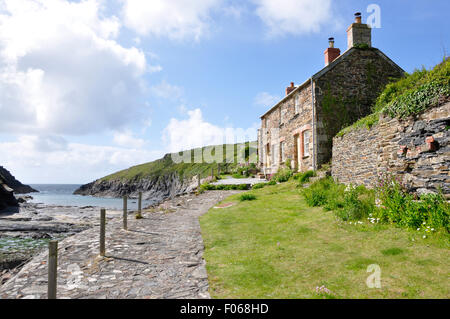 North Cornwall - Port Quin - scenic view path by traditional slate/stone built cottages to cliff tops and open sea - sunlight Stock Photo