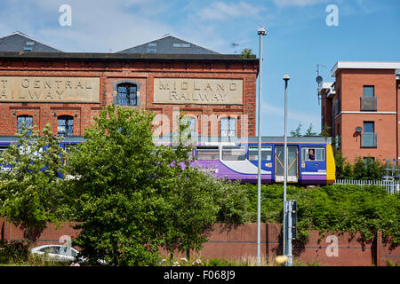 A Northern Rail 142 Pacer leaves Warrington Central with and old Midland Railway warehouse behind   Transport transporter transp Stock Photo