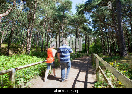 Formby Squirrel Reserve near Liverpool, UK. August 2015. Tourists visiting the Formby Squirrel Reserve to see the red squirrels in their natural environment & enjoy miles of coastal walks on a glorious summers afternoon.   Cars & visitors queued to enter so that they could enjoy breathtaking sea views or a picnic.  Couple taking a coastal walk to view Formby's fascinating coastline. Credit:  Cernan Elias/Alamy Live News Stock Photo