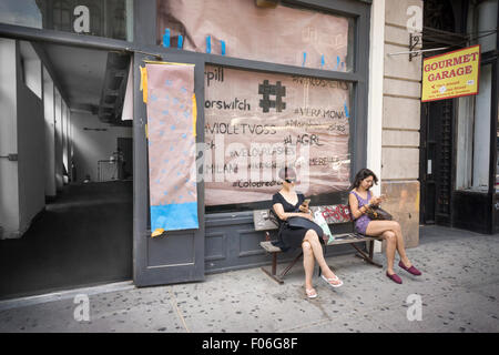 Tourists on their smartphones outside of a store under renovation on Broadway in Soho in New York on Sunday, August 2, 2015. (© Richard B. Levine) Stock Photo