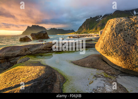 Midnight sun over Utakleiv beach on Lofoten islands in Norway with a natural pond in the foreground. Stock Photo