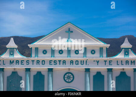 Little small blue and white small colonial church against a clear blue sky with a cross, basic decoration and letters Stock Photo