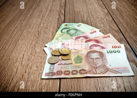 Thai banknote and coins on table Stock Photo