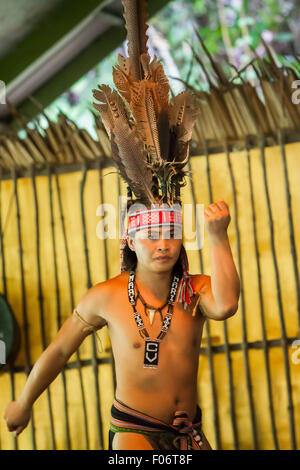 Portrait of a tourism worker wearing indigenous attire during an indigenous dance performance for tourists at Mari Mari Cultural Village, Sabah. Stock Photo
