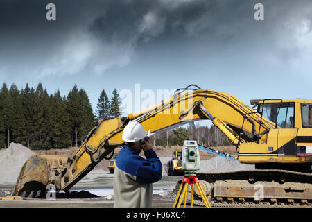 surveyor with measuring instrument and building site Stock Photo