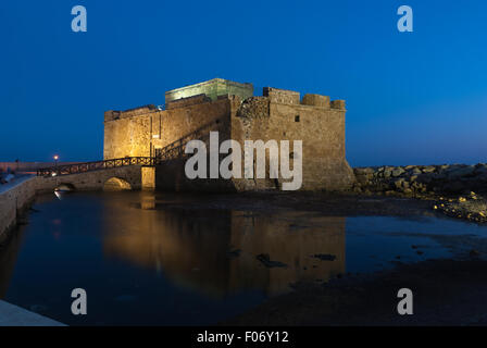 Illuminated Paphos Castle located in the city harbor at night with reflection in the water, Cyprus Stock Photo