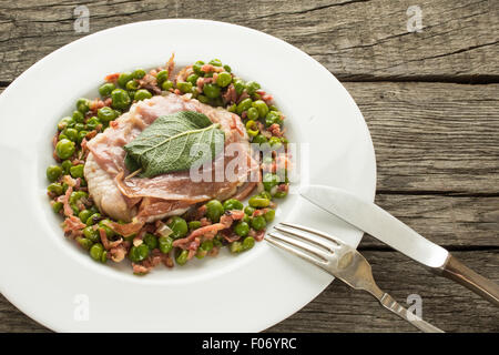 Veal with parma ham and sage on green peas Stock Photo