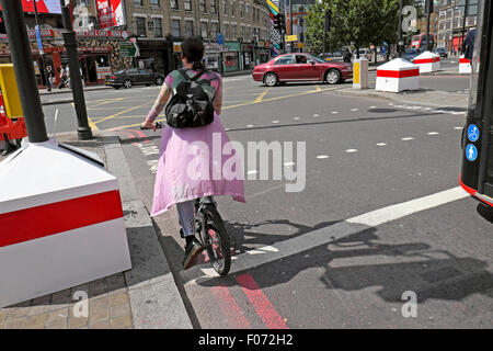 Young woman on bike waiting at traffic lights in Shoreditch East London  UK  KATHY DEWITT Stock Photo