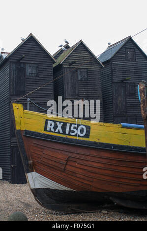 Hastings,  East Sussex, England. Winter. Fishermens huts for drying nets, with boat in front on Stade beach. Stock Photo