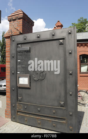 Blue sky portrait open metal gate, with 'PW' Kotwica 'anchor', Warsaw Uprising Museum entrance, Przyokopowa Street, Wola, Warsaw Stock Photo