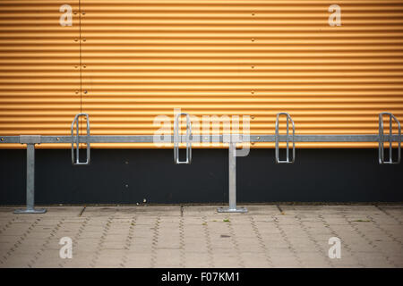 Bicycle stands in front of corrugated Stock Photo