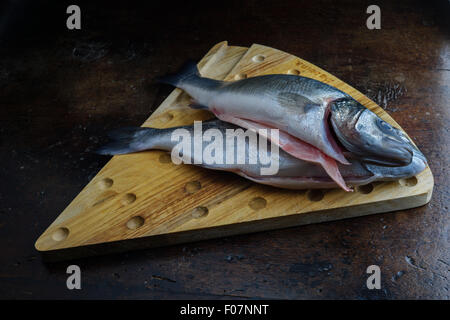 uncoucked fish on an old brown table Stock Photo
