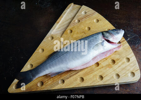 uncoucked fish on an old brown table Stock Photo