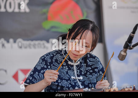 Queens, United States. 09th Aug, 2015. Wendy Li performs on a yangqin, a traditional Chinese hammed dulcimer, during a concert of traditional music on the festival's second morning. The two-day 25th Annual Hong Kong Dragon Boat Festival was held in Flushing Meadows-Corona Park. Credit:  Albin Lohr-Jones/Pacific Press/Alamy Live News Stock Photo
