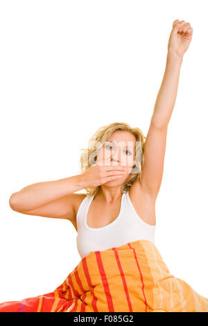 Tired woman yawning after waking up in bed Stock Photo