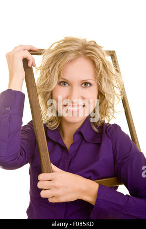 Happy woman climbing through an empty picture frame Stock Photo