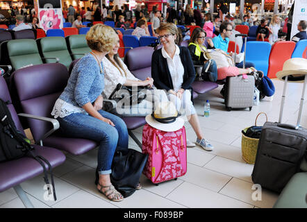 Women chatting looking happy in Departure lounge of Gatwick Airport South Terminal going on holiday together Stock Photo