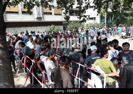 Berlin, Germany. 10th Aug, 2015. Refugees queue up in front of the 'Landesamt für Gesundheit und Soziales Berlin' (LaGeSo, lit. State Office for Health and Social Affairs) during hot summer weather in Berlin, Germany, 10 August 2015. Credit:  dpa picture alliance/Alamy Live News Stock Photo