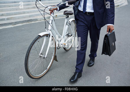 Businessman with briefcase and bicycle going to work Stock Photo