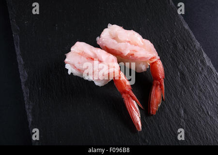 two sushi shrimp on slate plate, black background Stock Photo