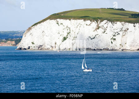 A yacht passing The Foreland or Handfast Point and Ballard Down between Studland Bay and Swanage Bay near Swanage, Dorset UK Stock Photo