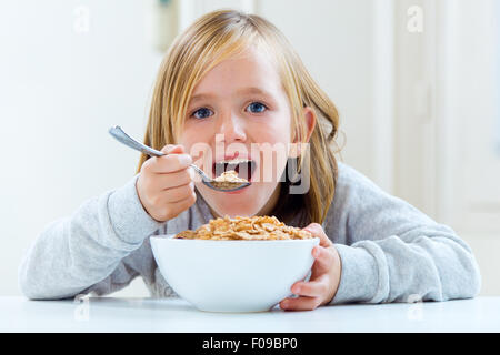 Portrait of beautiful child having breakfast at home. Stock Photo